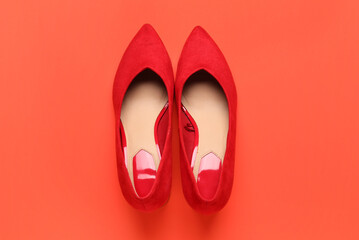 Pair of stylish female shoes on color background