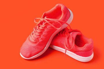 Pair of stylish female sneakers on color background
