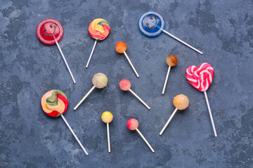 Different sweet lollipops on blue grunge table