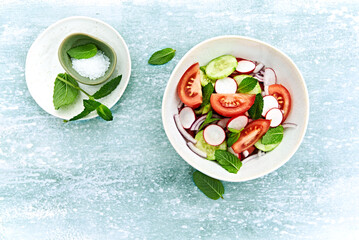 Spring tomato and cucumber salad with radishes and mint leaves - 599069979