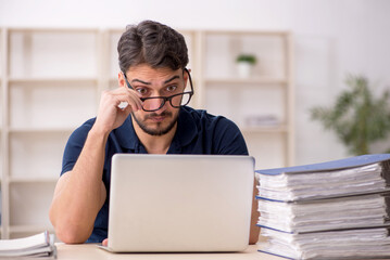 Young male employee sitting at workplace