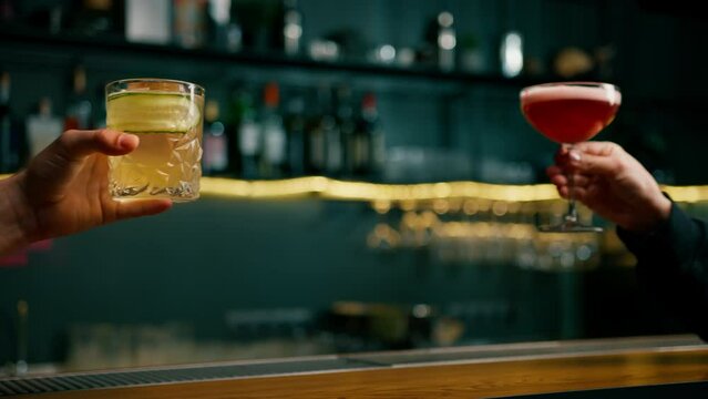 Close up of two people cheering cocktails in a bar or disco club drinks and cocktails concept