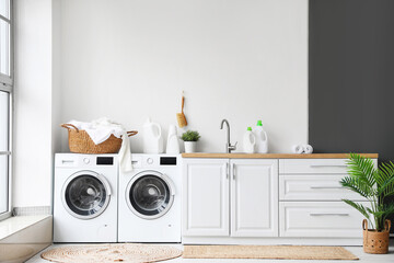 Interior of laundry room with washing machines and dirty clothes