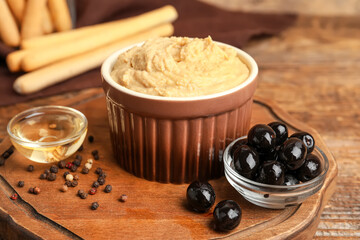 Bowl with tasty hummus on wooden background