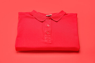 Folded red t-shirt on color background