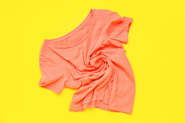 Crumpled pink t-shirt on yellow background