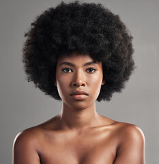 My skin feels as smooth as it looks. Studio shot of a young female posing against a grey background.