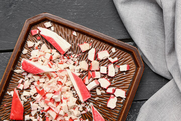 Plate with tasty cut crab sticks on dark wooden background, closeup © Pixel-Shot