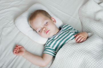 Naklejka premium Toddler boy sleeping close-up on bed. Health care concept