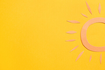 Paper sun on yellow background