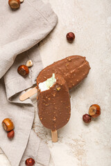 Tasty chocolate covered ice cream on light background