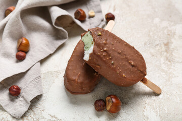 Tasty chocolate covered ice cream on light background