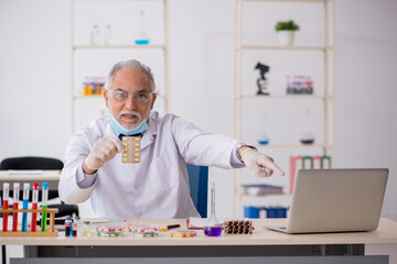 Old male chemist in drug synthesis concept