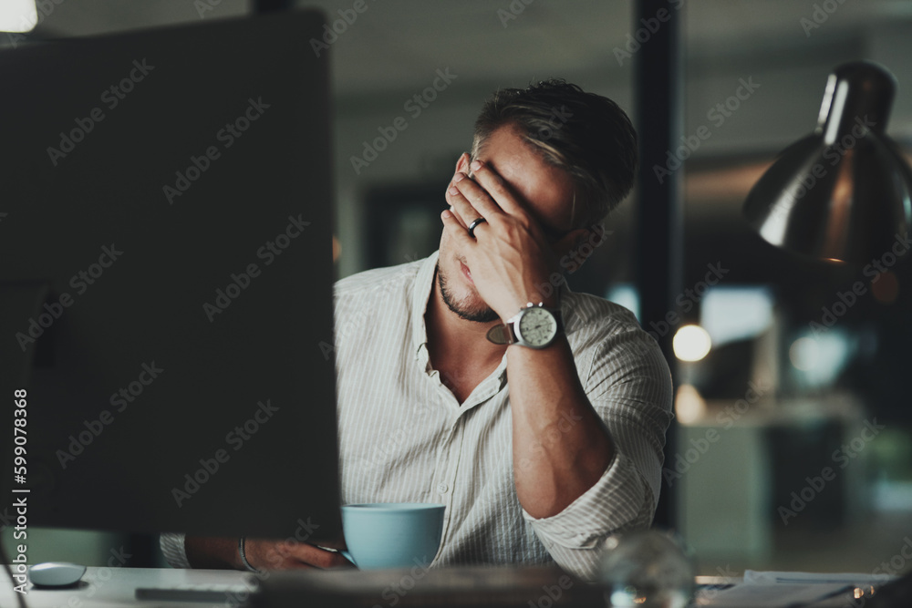 Poster Its impossible to concentrate with this headache. a young businessman looking stressed out while working on a computer in an office at night.