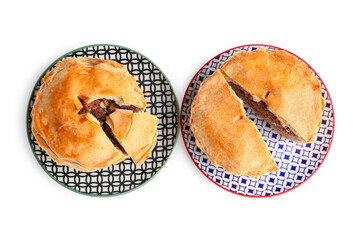 Plates with tasty meat pot pie on white background