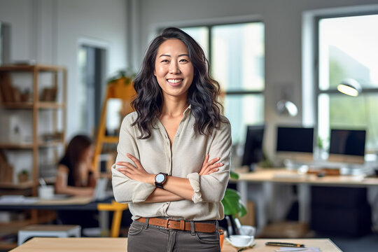 Casual portrait of a designer in her office standing by her desk, daylight coming through the window, corporate photography, Asian woman. made with ai