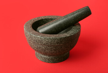 Mortar and pestle on red background