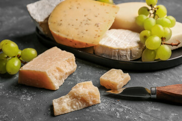 Pieces of tasty Parmesan cheese on blue background