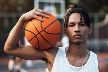 Keep your head up, champion. Portrait of a sporty young man standing on a basketball court.