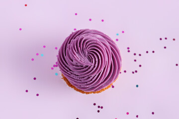 Tasty cupcake on purple background