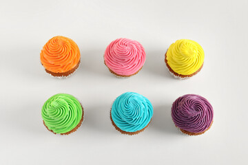 Tasty colorful cupcakes on white background