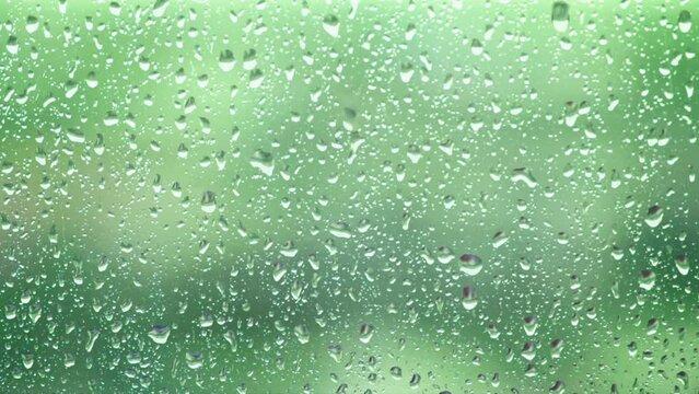 Close up of raindrops on the window on green background. Seamless loop. Generative AI