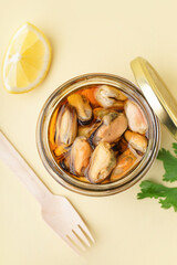 Jar with pickled mussels on beige background