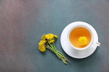 Cup of healthy dandelion tea on dark background