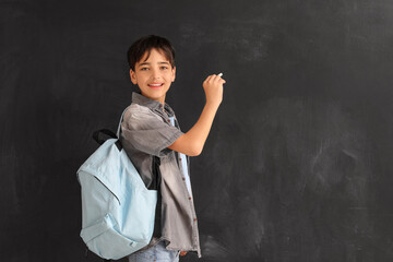 Little boy with chalk piece drawing on blackboard. Children's Day celebration