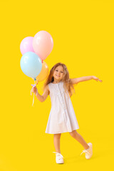 Fototapeta na wymiar Little girl with balloons on yellow background. Children's Day celebration