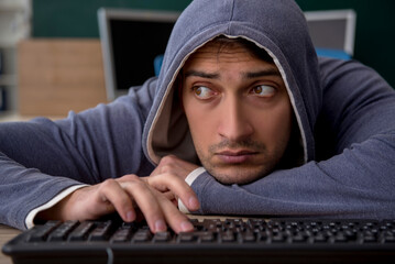 Young male hacker sitting in the classroom