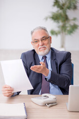 Old male employee working in the office