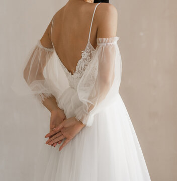 Gorgeous long wedding backless dress. Bride in the shoulderless white wedding dress with fancy sleeves