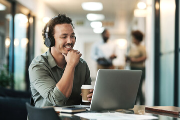 Listening is part of the planning process. a young businessman sitting in the office and wearing headphones while using his laptop for a virtual meeting. - Powered by Adobe