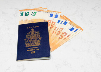 Canadian Passport and EURO bills on a white marble background