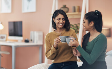 Having a sister means you have a best friend for a lifetime. two young women drinking coffee while sitting together at home.