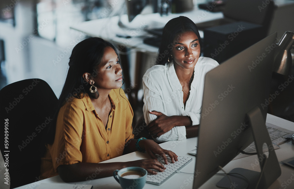 Poster adding final touches to their big plan. two young businesswomen working together on a computer in an