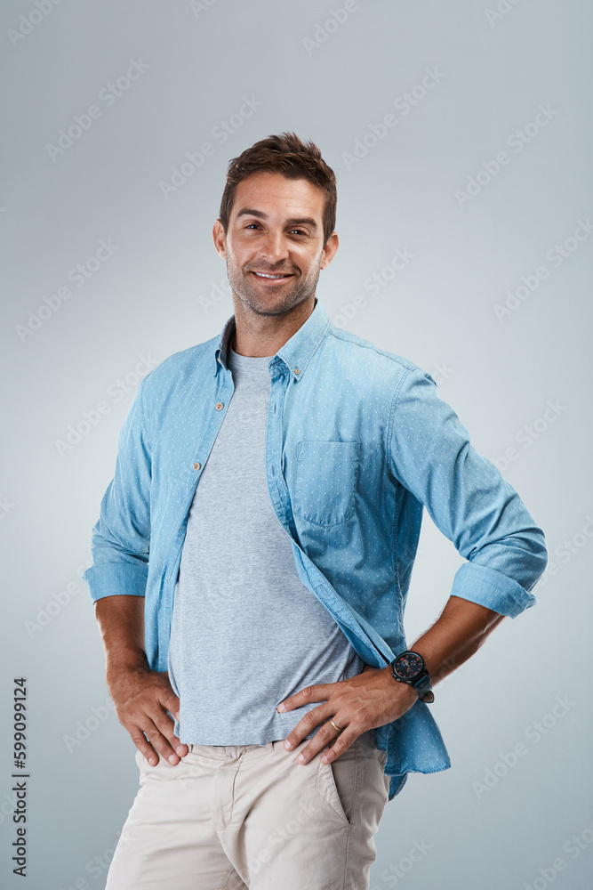 Poster here to save the day. portrait of a cheerful young man smiling brightly while standing against a gre