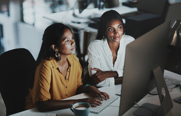 Adding final touches to their big plan. two young businesswomen working together on a computer in...
