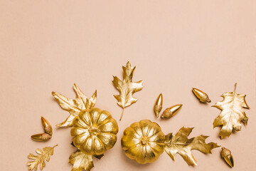 Gold painted leaves, pumpkins and acorns, autumn season composition