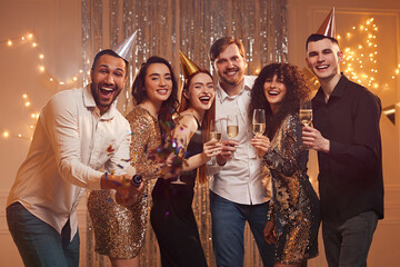 Happy friends with glasses of wine and sparklers celebrating birthday indoors
