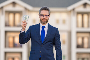 Man in suit holding cash money in dollar banknotes outdoor. Portrait of businessman with bunch of dollar banknotes. Dollar money concept. Career wealth business. Insurance agent.