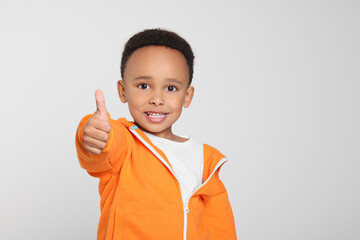 African-American boy showing thumb up on light grey background