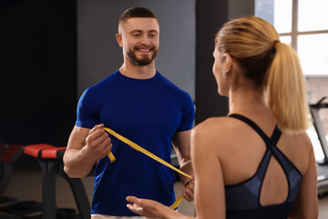 Trainer having discussion with woman in gym