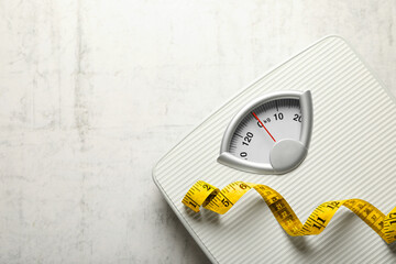 Weigh scales and measuring tape on white textured background, top view with space for text. Overweight concept - obrazy, fototapety, plakaty