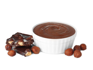 Chocolate pieces, bowl of sweet paste and hazelnuts on white background