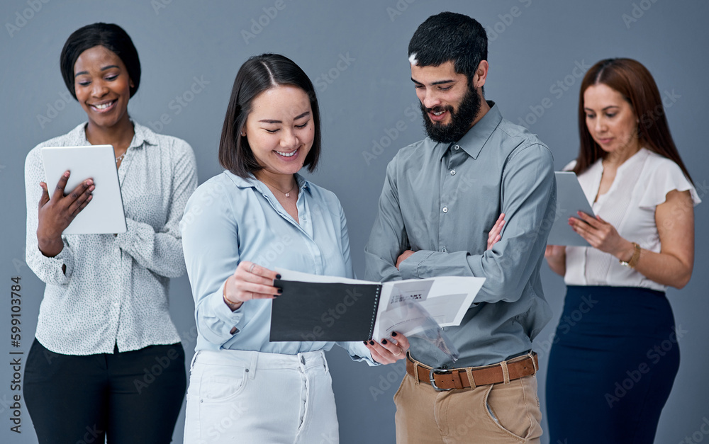 Poster a heavy workload can be made much lighter through teamwork. two businesspeople going through paperwo