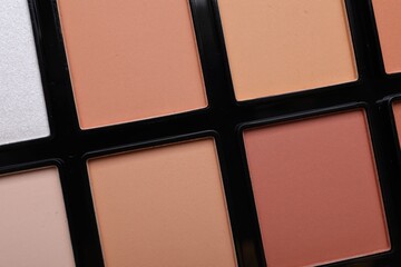 Colorful contouring palette as background, closeup. Professional cosmetic product