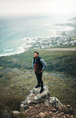 Obraz premium If you think youve peaked, find a new mountain. a young man standing on a cliff while out on a hike.