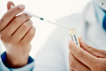 Ive got you covered against Covid. a scientist extracting medication using a syringe from an...